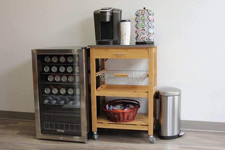 Recorrido por la oficina: área de café con carrito de bebidas, refrigerador en miniatura, refrescos, café y bote de basura